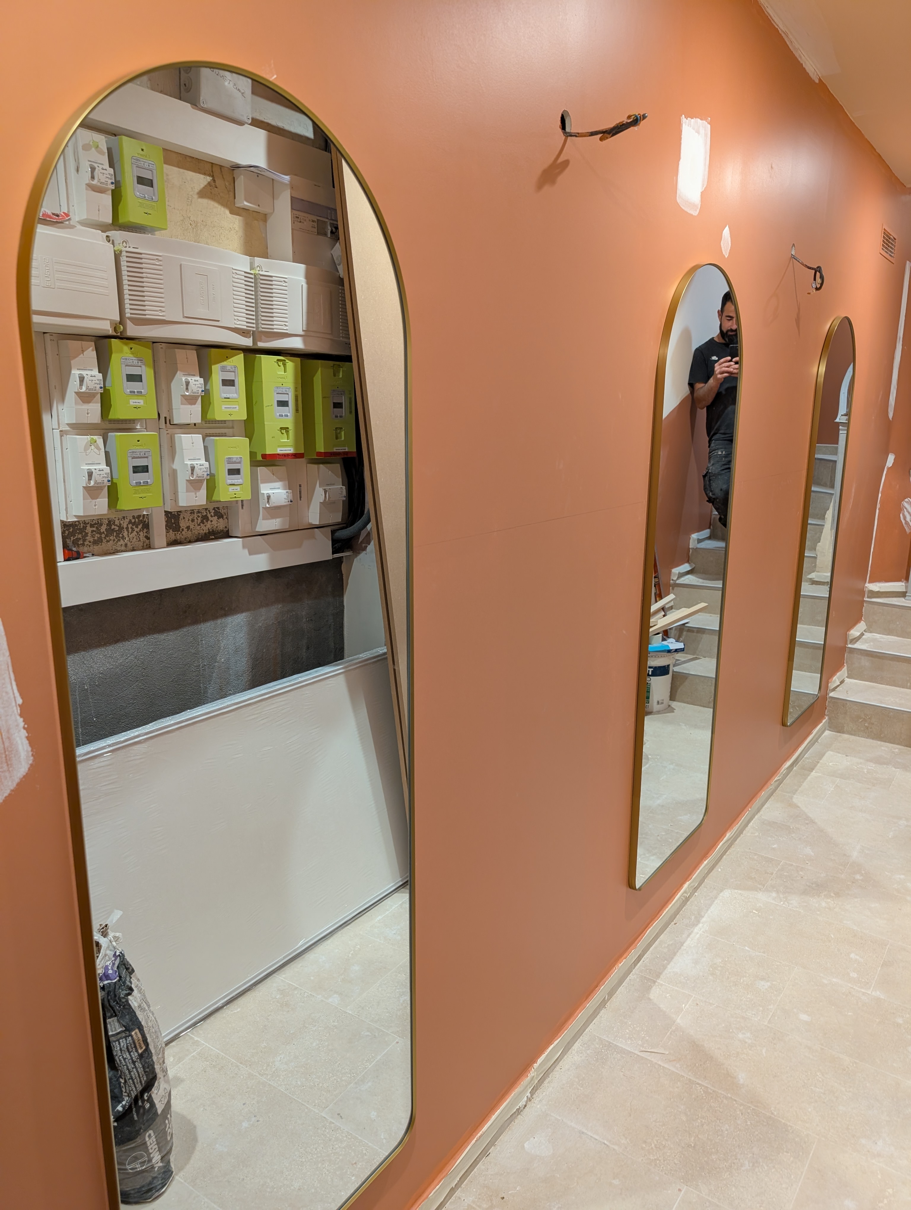 Aménagement intérieur d'un local commercial — couloir avec miroirs en arche et carrelage travertin dans le Var par Provence Bati Travaux